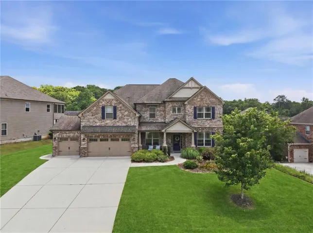 Two-story brick and stone facade residence featuring multiple gables and a covered front entry