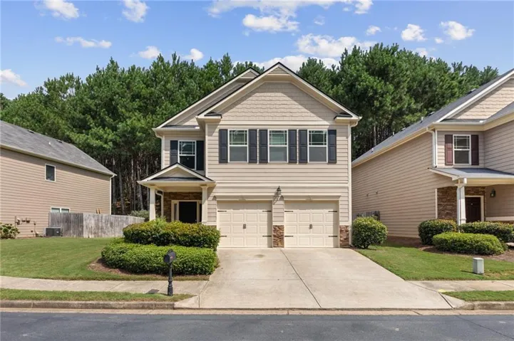 Two-story residence featuring a two-car garage, stone accents, and a covered entry
