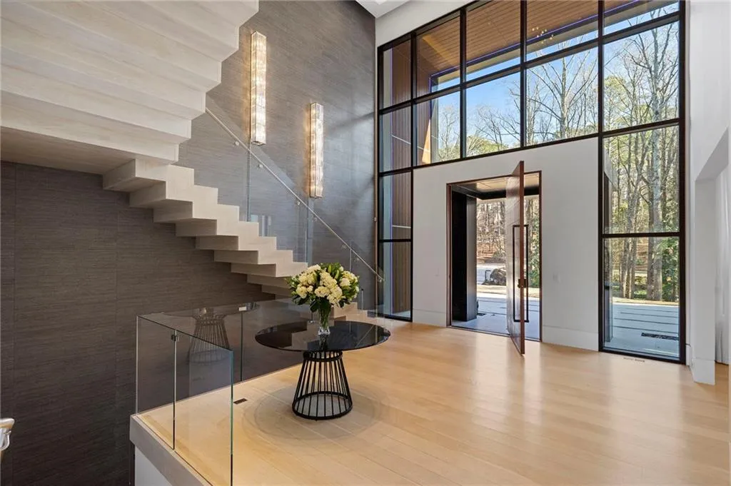 Massive pivot door opens into a dramatic 24 foot foyer with custom designed steel and glass stair.