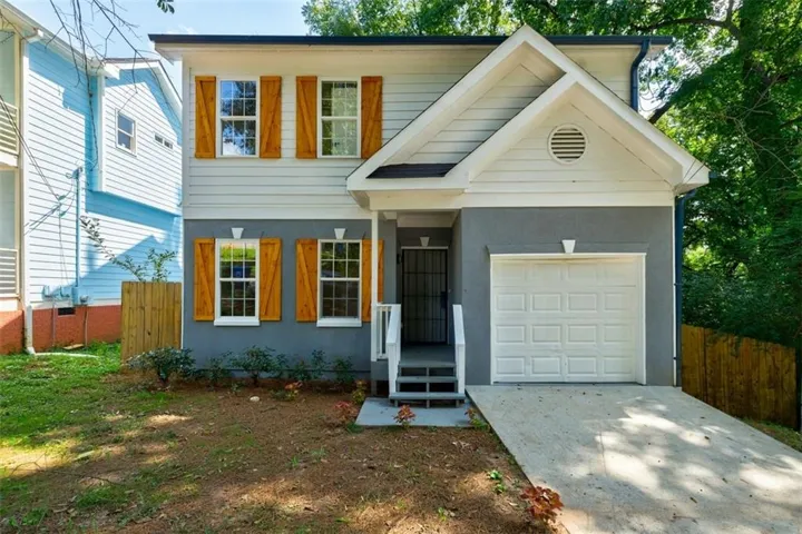 Two-story exterior with light gray siding, white trim, and a gray stucco foundation