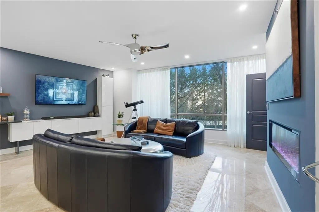 Living room with a ceiling fan, recessed lighting, and an electric insert fireplace