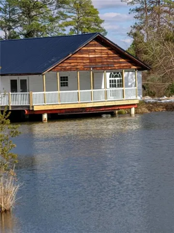 View of front facade featuring a water view and metal roof