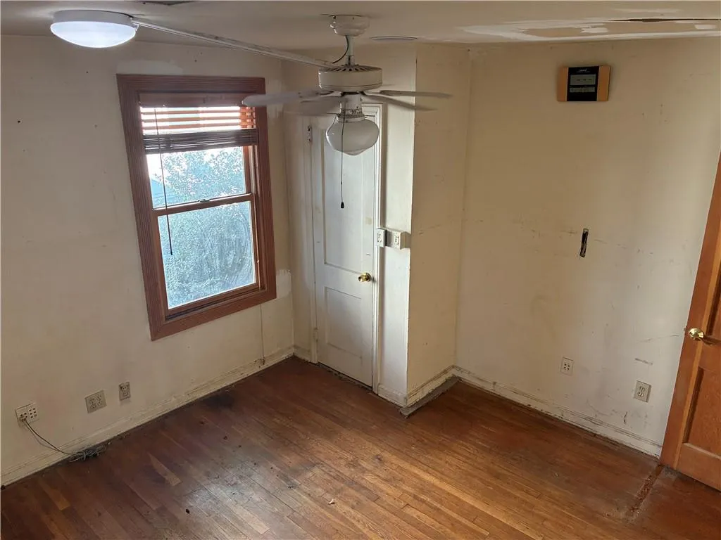 Unfurnished dining area featuring dark wood finished floors and a ceiling fan