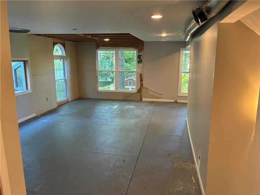 Empty room featuring concrete flooring and baseboards