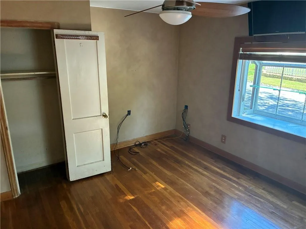 Unfurnished bedroom with dark wood-style floors and ceiling fan