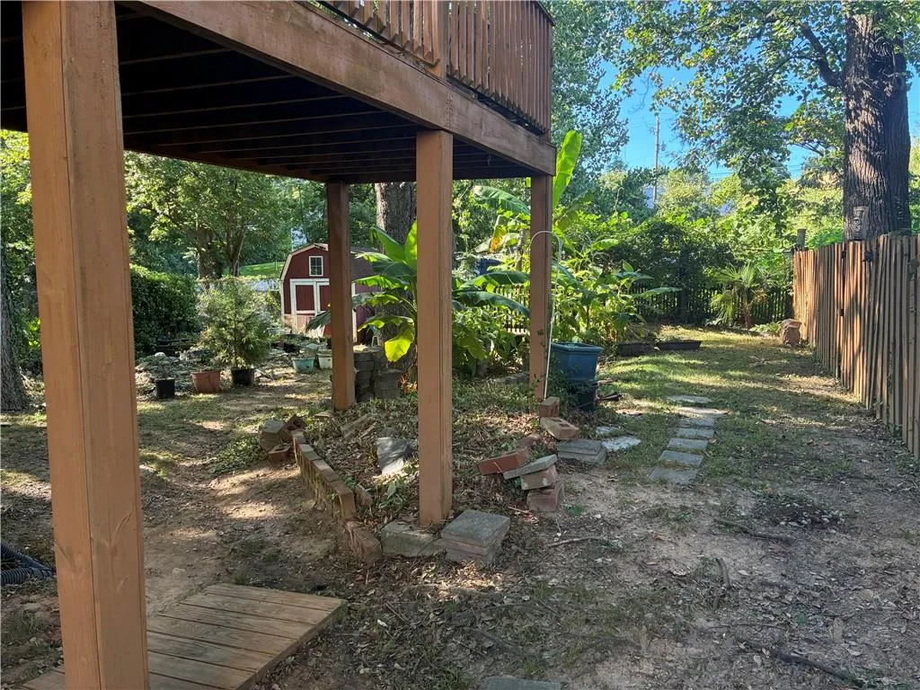 View of yard featuring a storage unit and a wooden deck