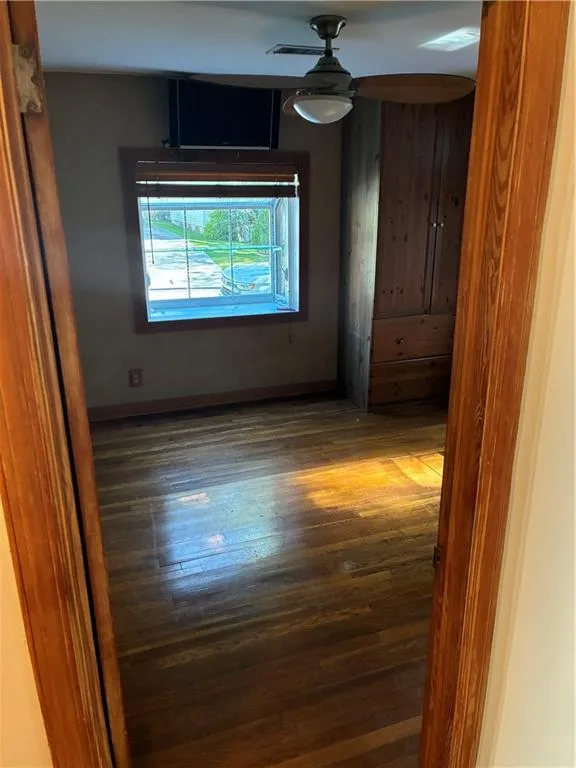 Unfurnished room with baseboards and hardwood / wood-style floors