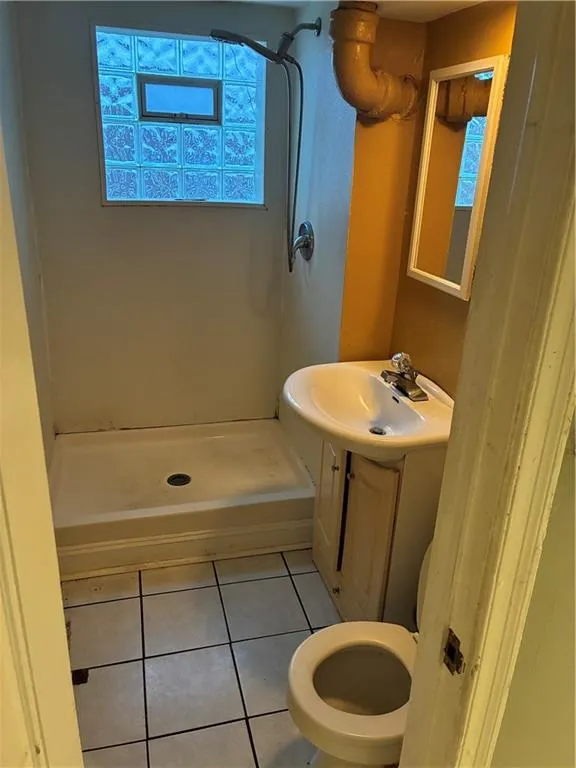 Full bath with light tile patterned floors, vanity, and a shower stall