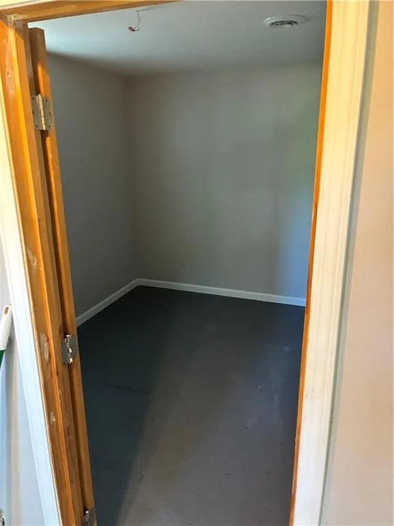 Spare room featuring concrete floors and baseboards