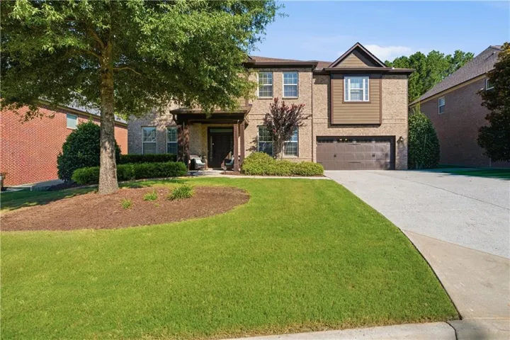Brick exterior with a prominent front gable, covered entry, attached garage, and a concrete driveway