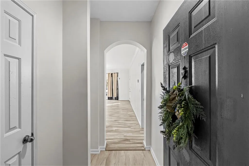 Hall with arched walkways and light wood-type flooring