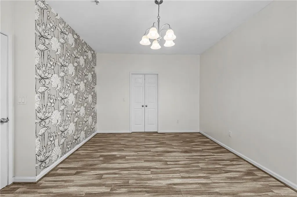 Unfurnished dining area featuring hanging lights and wood finished floors