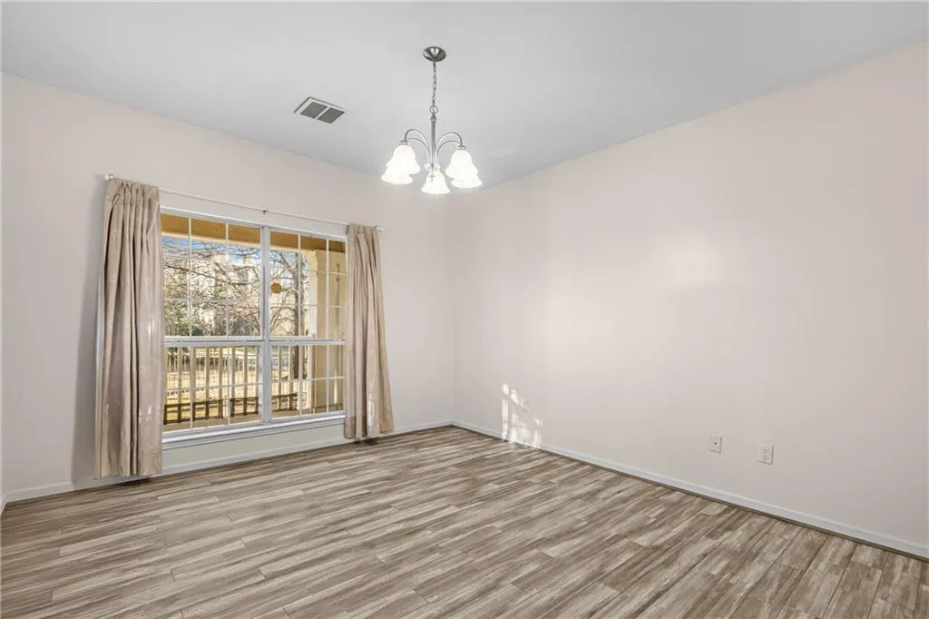 Spare room with hanging lights and light wood finished floors