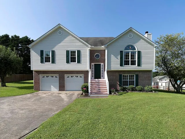 Two-story home featuring a brick and siding exterior with a prominent front entrance