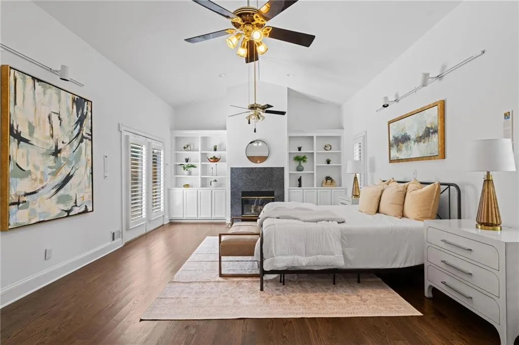 oversized primary suite with fireplace and builtins