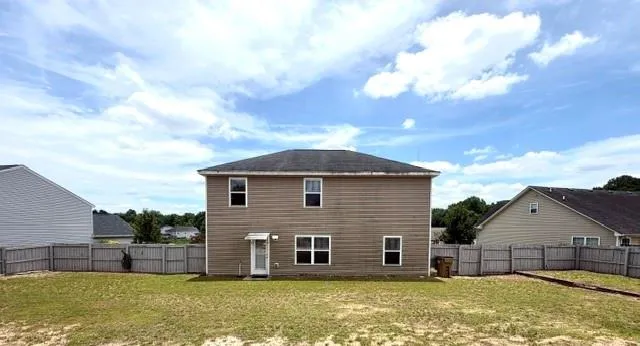 Rear elevation featuring horizontal siding, multiple windows, and a back entry door