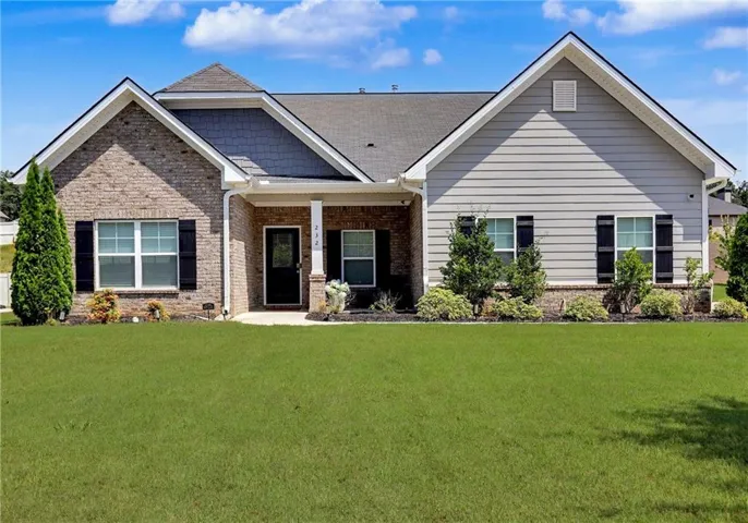Brick and siding exterior, front lawn, covered entry, gabled rooflines, and dark window shutters