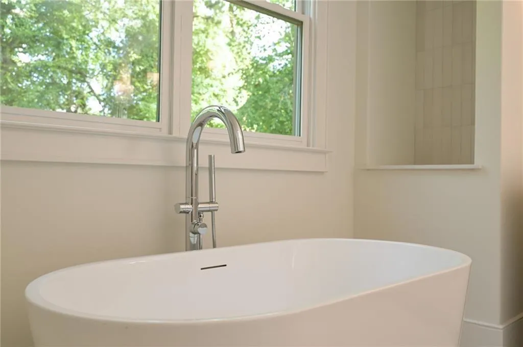 Bathroom with a tub, plenty of natural light, and sink