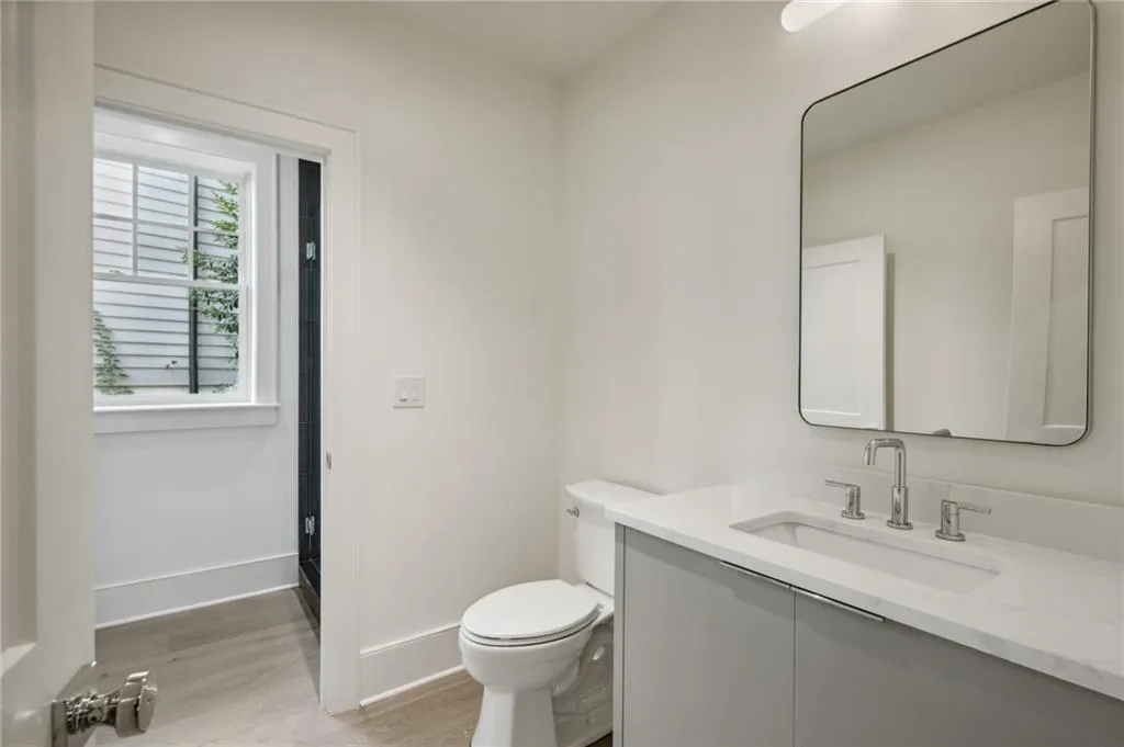 Bathroom with vanity, hardwood / wood-style floors, and toilet