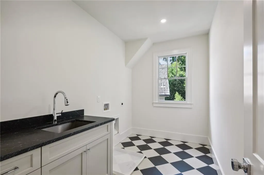 Clothes washing area featuring cabinets, washer hookup, hookup for an electric dryer, and sink
