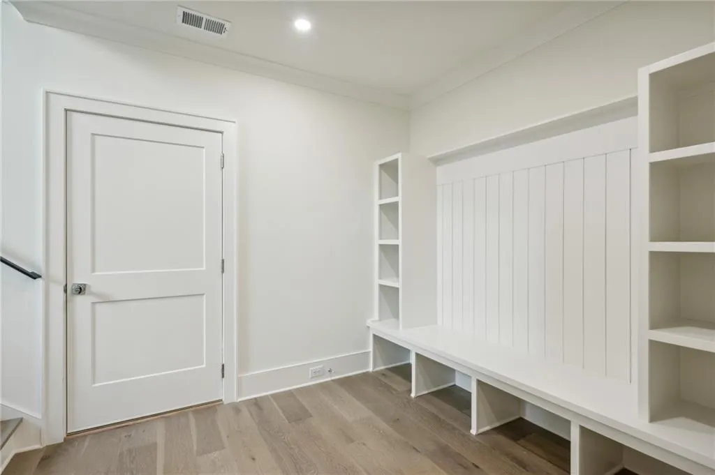 Mudroom with crown molding and light hardwood / wood-style flooring
