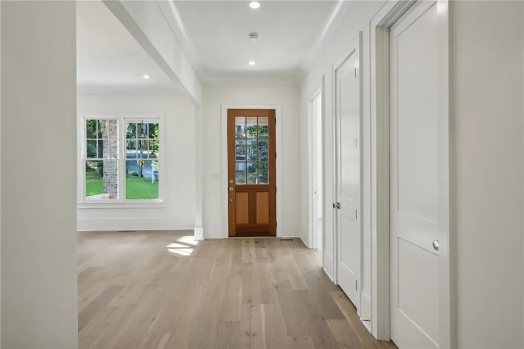 Doorway to outside with crown molding and light hardwood / wood-style flooring