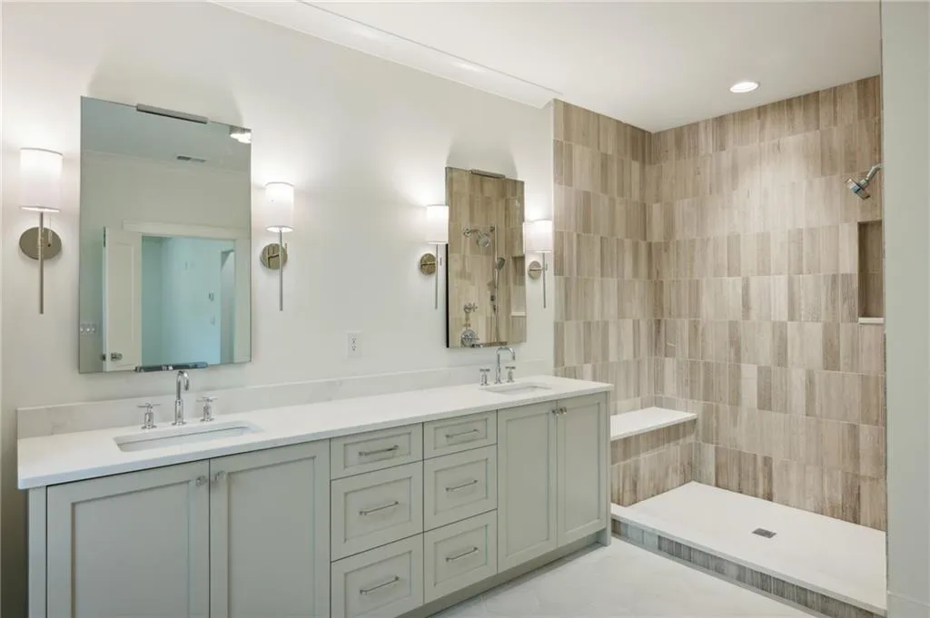 Bathroom with vanity, a tile shower, and crown molding