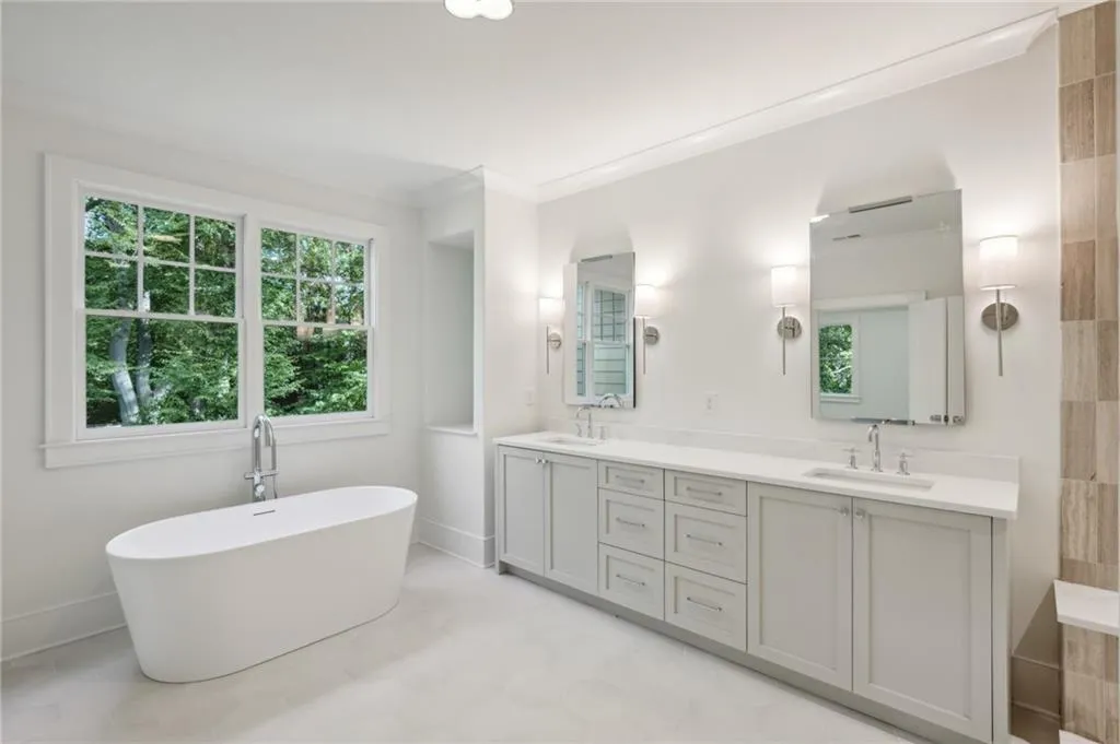 Bathroom with ornamental molding, a bathing tub, and vanity