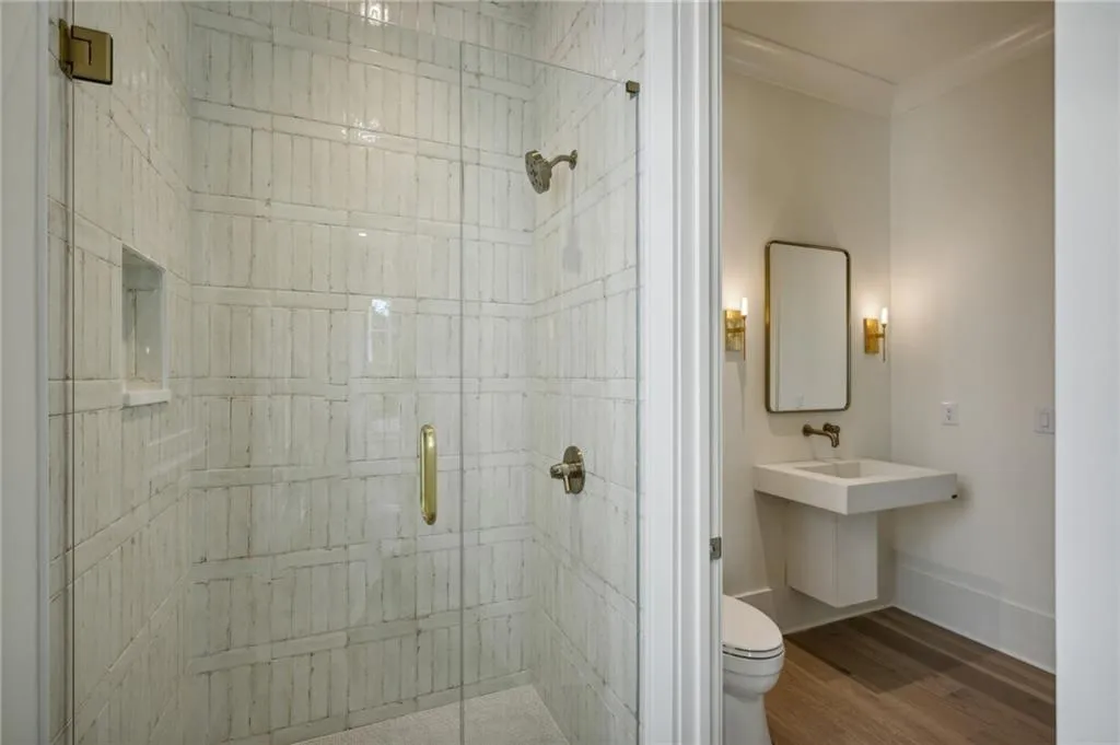 Bathroom with wood-type flooring, toilet, and walk in shower