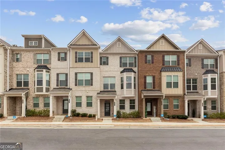 Townhome exteriors featuring brick and siding facades, bay windows, gabled rooflines, and covered front entrances