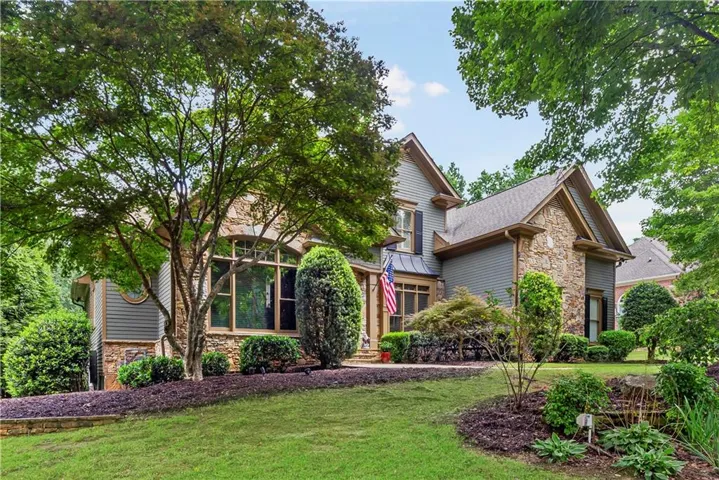 Stone and siding exterior with mature landscaping