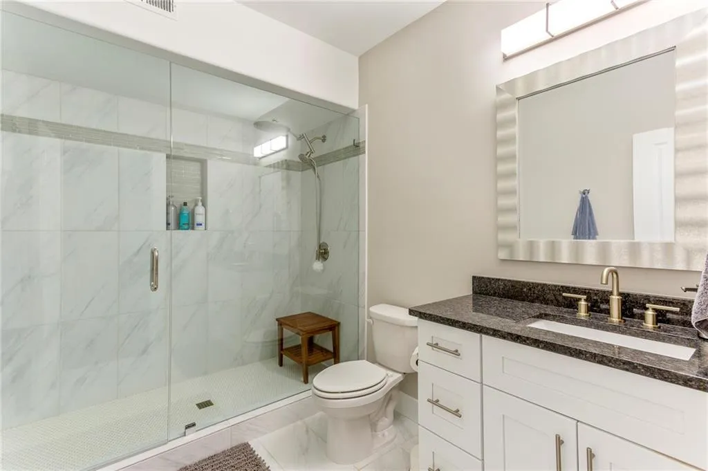 Bathroom with vanity, toilet, and a shower with door