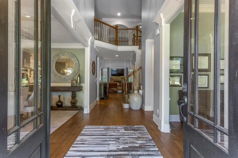 Foyer entrance featuring crown molding, dark hardwood / wood-style floors, and a towering ceiling