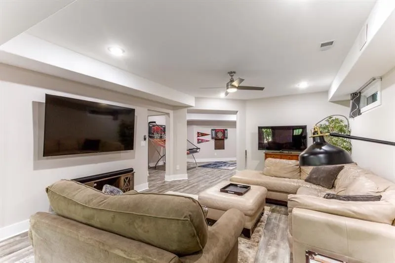 Living room with ceiling fan, a fireplace, and light wood-type flooring