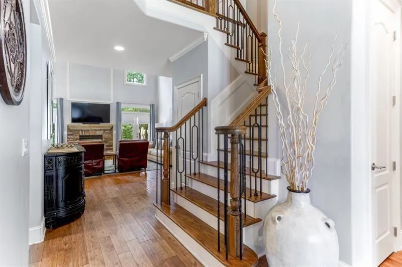 Stairway featuring crown molding, hardwood / wood-style flooring, and a stone fireplace