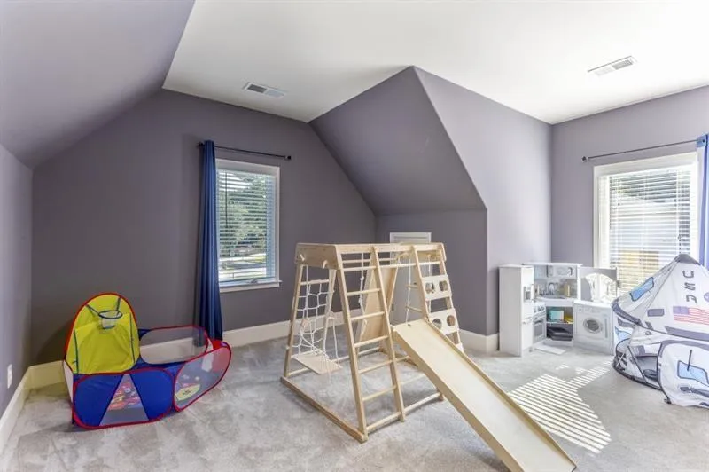 Recreation room with lofted ceiling, plenty of natural light, and carpet flooring