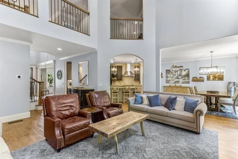 Living room with an inviting chandelier, ornamental molding, and wood-type flooring