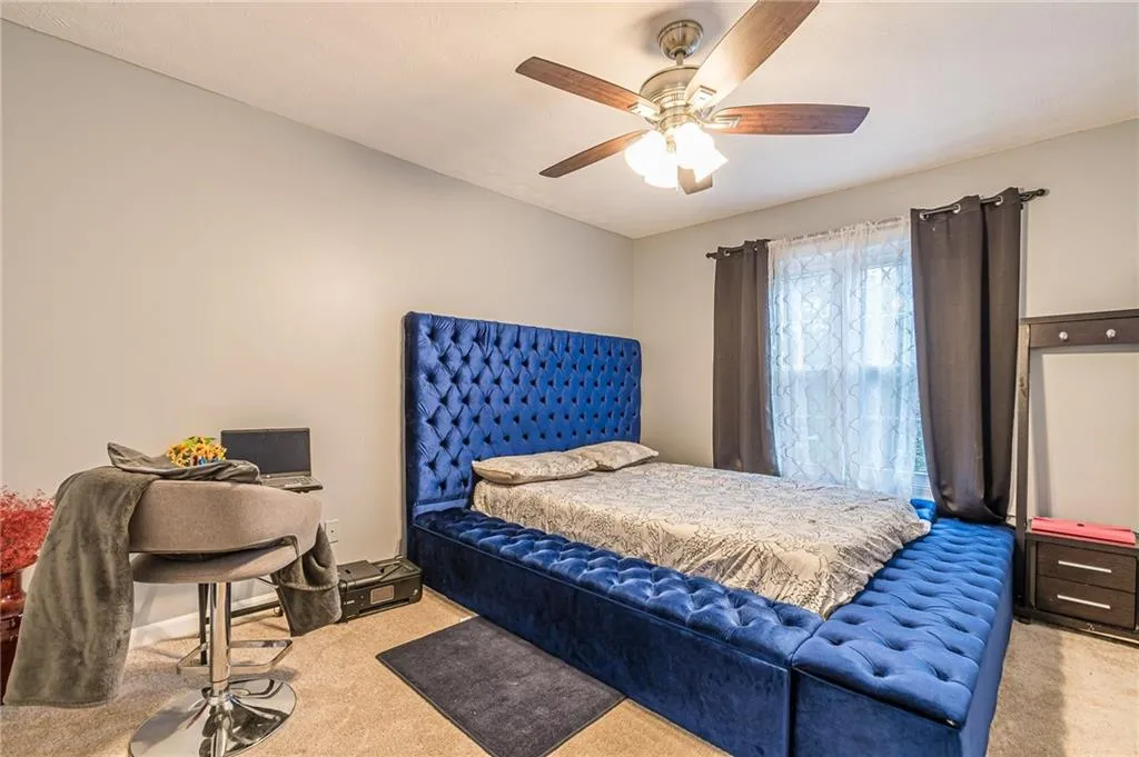 Bedroom with light carpet and ceiling fan