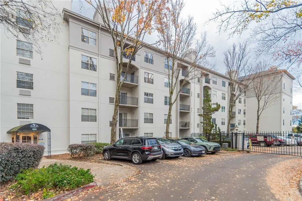View of apartment building / complex with uncovered parking