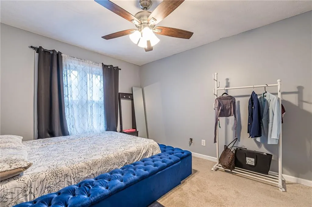 Carpeted bedroom with baseboards and ceiling fan
