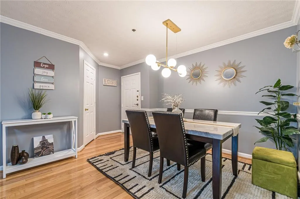 Dining area featuring ornamental molding, light wood-style floors, and a chandelier