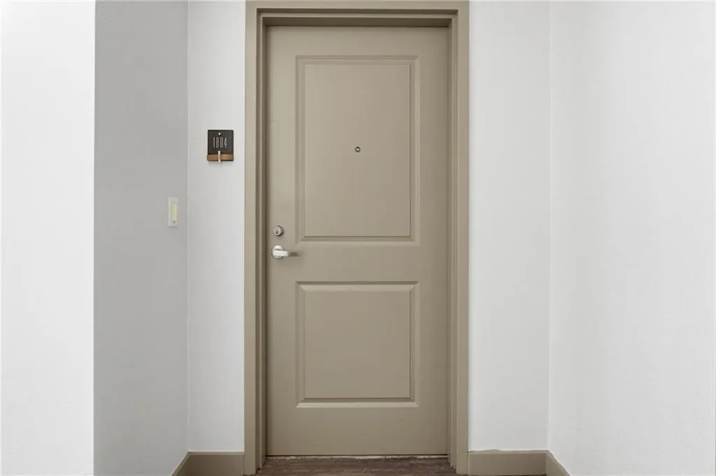 Raised panel entry door with a privacy viewer, brushed nickel hardware, and coordinating trim