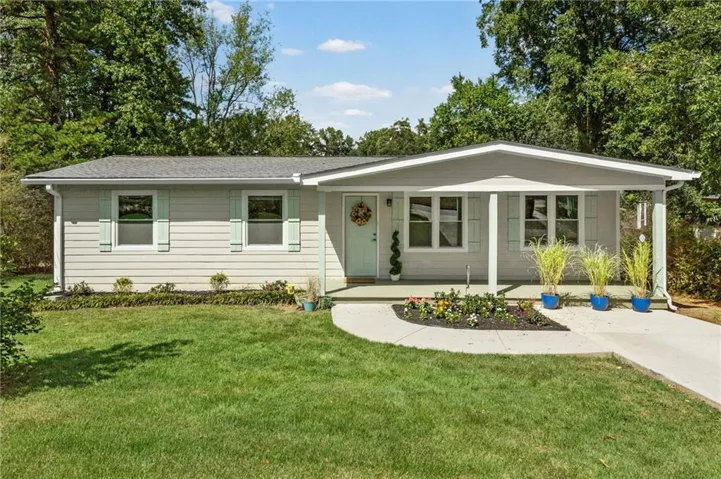Ranch-style exterior with light gray siding, a covered front porch, and mint green shutters
