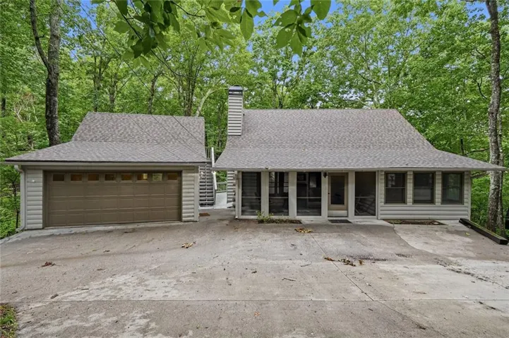 Exterior featuring a two-car garage with a brown sectional door, and a screened porch