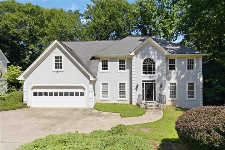Traditional-style residence featuring a prominent arched window above the main entry