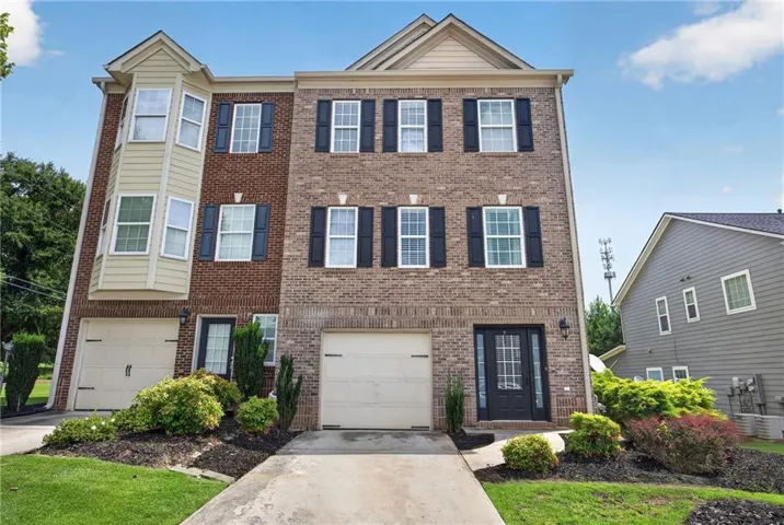 Townhome exterior featuring a brick facade with a prominent bay window