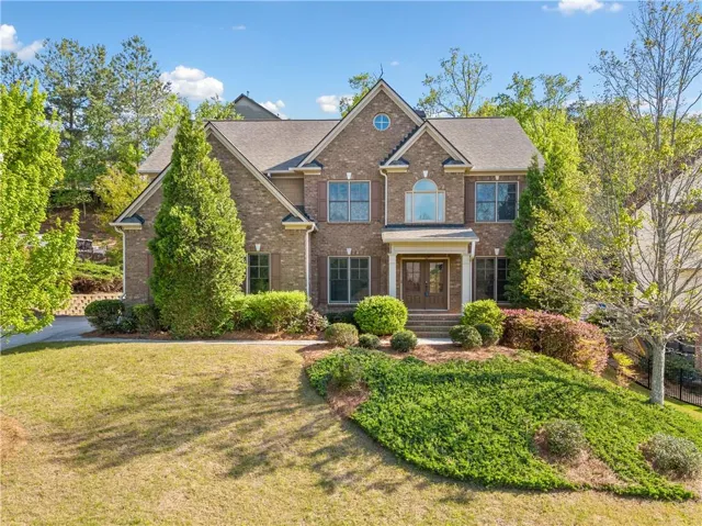 Brick exterior with multiple gables, arched windows, and a covered entry porch