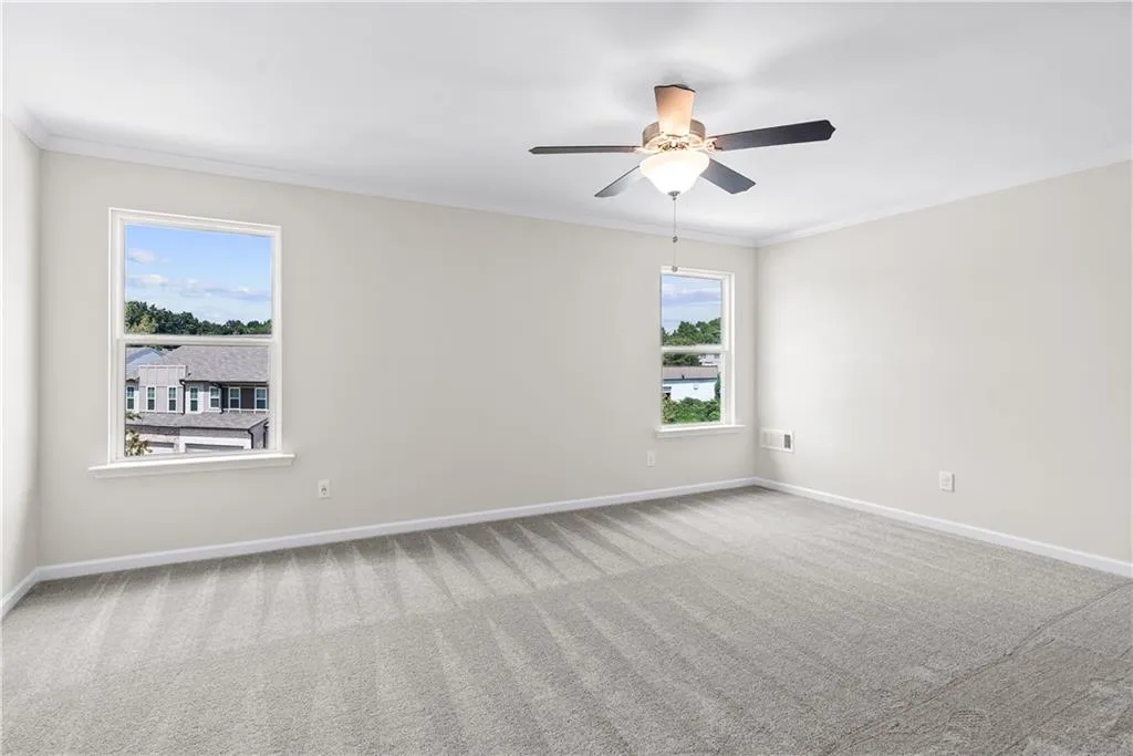 Unfurnished room featuring crown molding, carpet, and ceiling fan