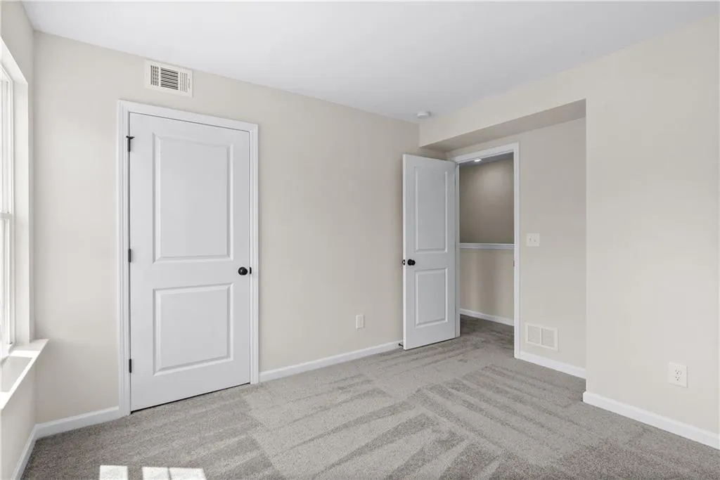 Unfurnished bedroom featuring light colored carpet