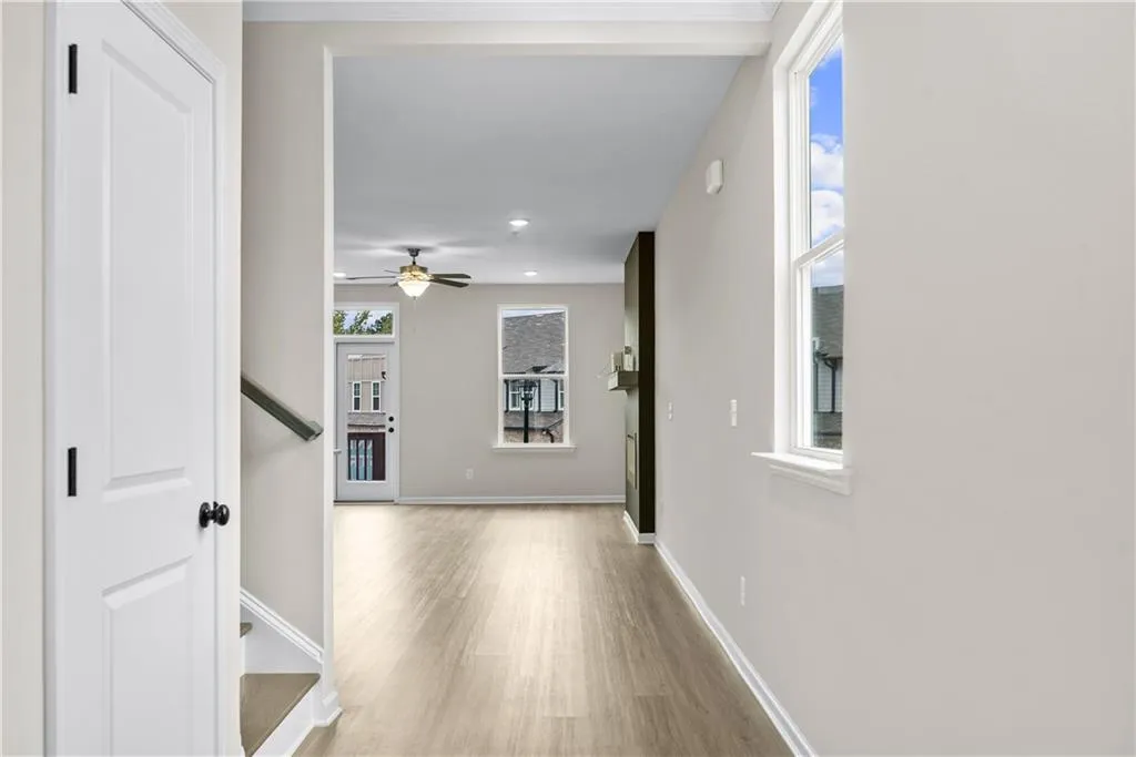 Hallway with light wood-style flooring, stairway, and recessed lighting